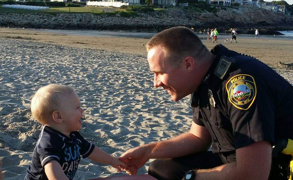 Officer McKinnon greeting a child at the beach